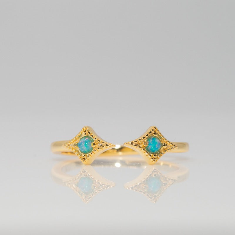 Gold cuff ring with two small round opal stones